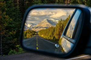 Mountain highway reflected in a car's side mirror