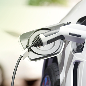 Close up of an electric vehicle being charged with a nozzle