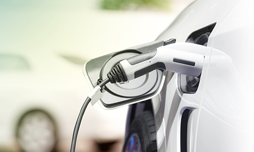 Close up of an electric vehicle being charged with a nozzle