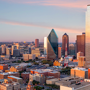 Aerial view of downtown Dallas TX with warm sunset .